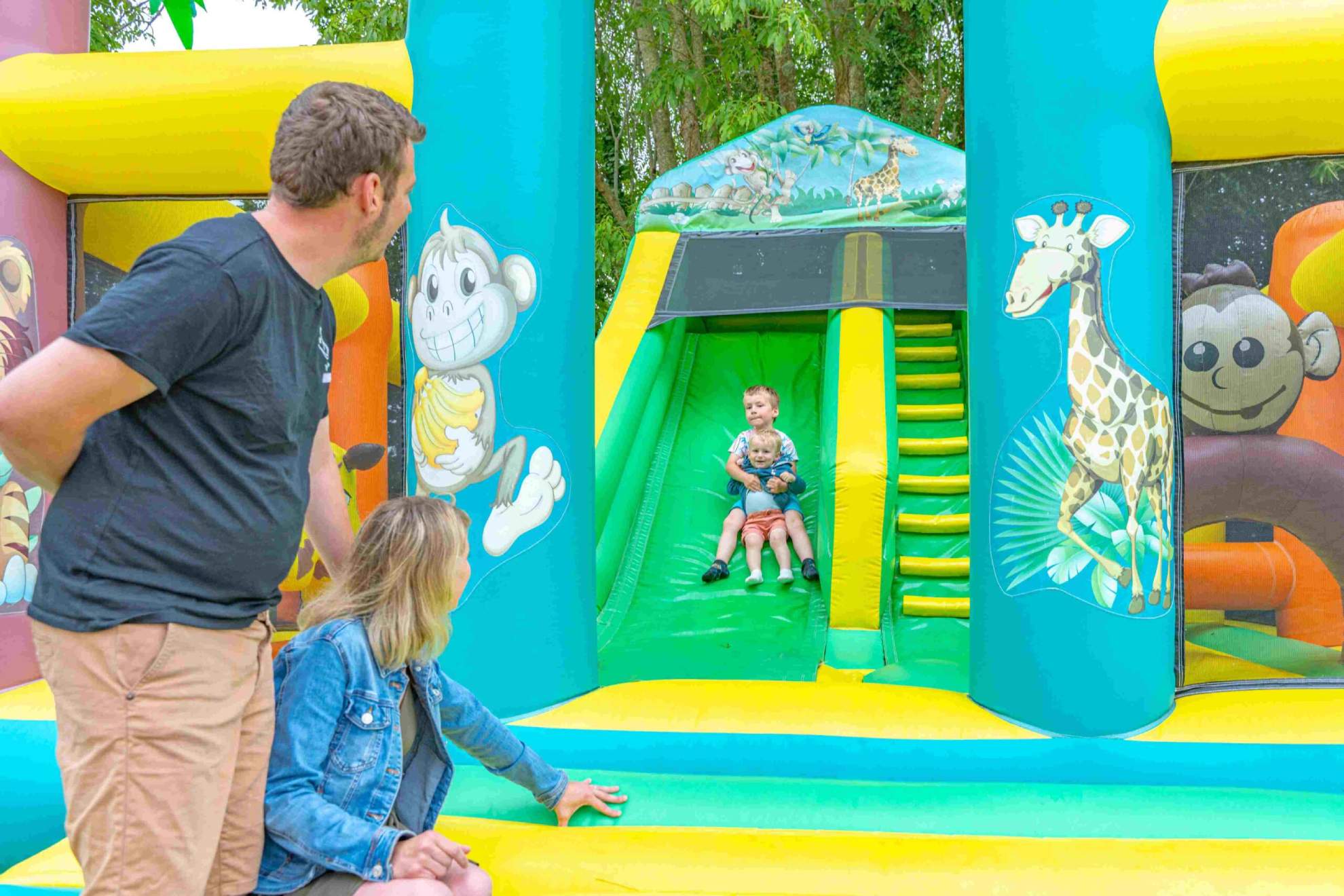 Kinderen glijden van een kleurrijke opblaasbare glijbaan.